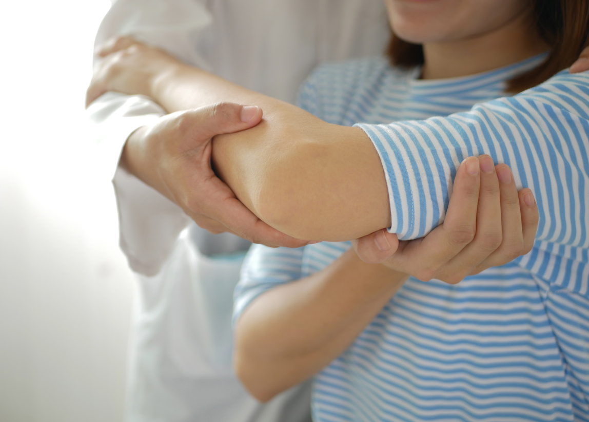 Asian female patient doing physical therapy with physical therapist Perform pain therapy in a hospital