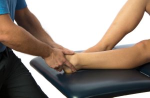 a therapist pulling on a patients ankle