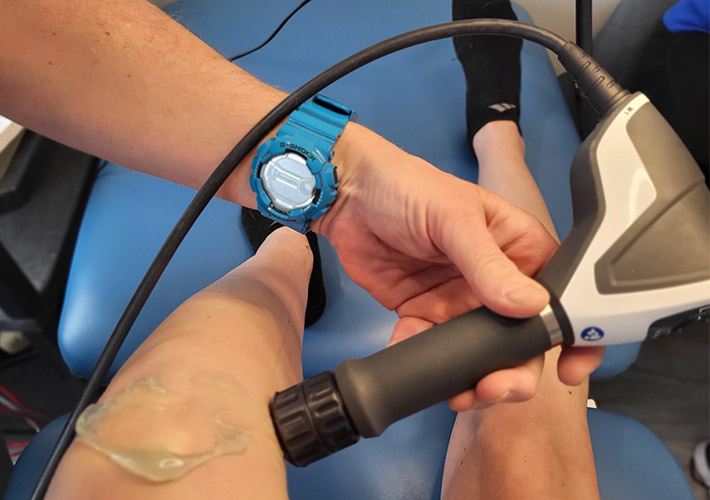A shockwave gun being used on patient to cure Arthritis 