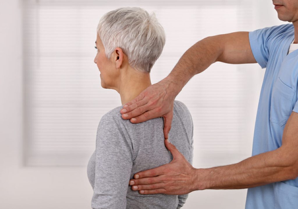 Mature Woman having chiropractic back adjustment.