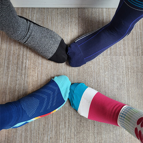 4 people wearing compression socks and standing in circle