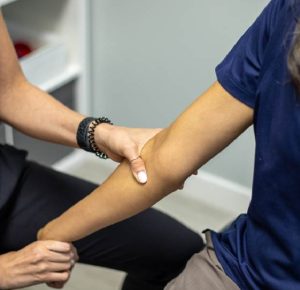 a patient getting a deep massage on their elbow