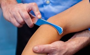 a small metal tool used to scrape the area around the elbow