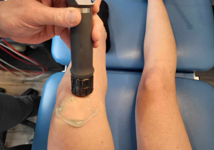 A patient receiving shockwave therapy for knee pain