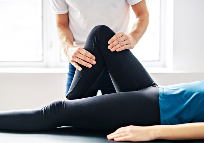 A chiropractor treating patient for knee pain