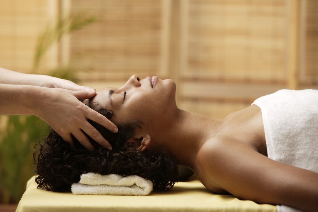 Young woman having her head massaged