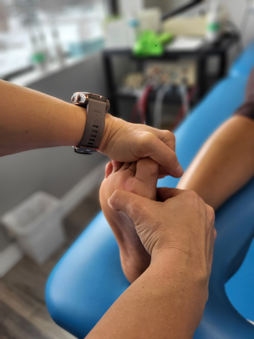A physiotherapist pressing trigger points for mortons neuroma 
