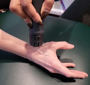shockwave therapy being applied to a patients thumb
