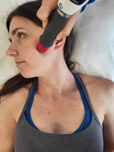 Female patient receiving shockwave treatment for Jaw pain