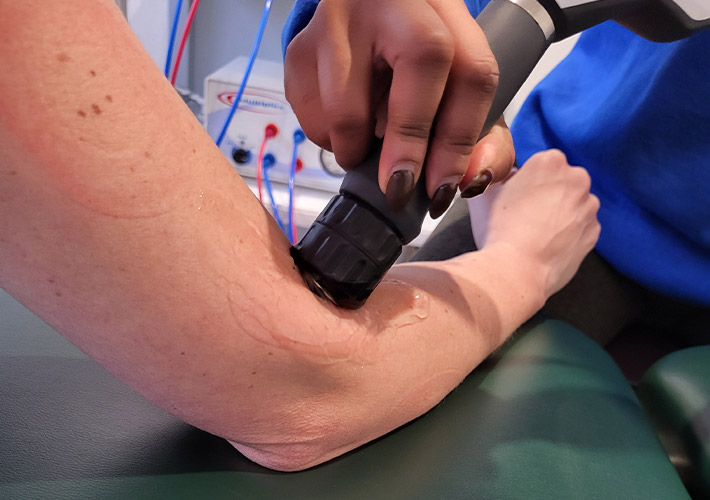 A patient getting shockwave treatment for elbow pain