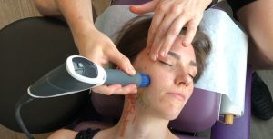 female getting right jaw treated with shockwave, shockwave is a hand held pneumatic gun, hits 15 times a second for 90 seconds