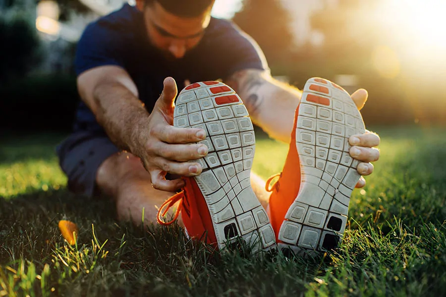 A person stretching his legs while sitting on ground
